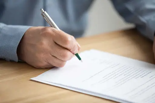 A man signs a will.
